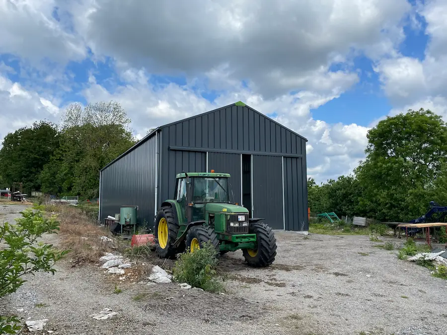 Tracteur devant un hangar agricole en Wallonie
